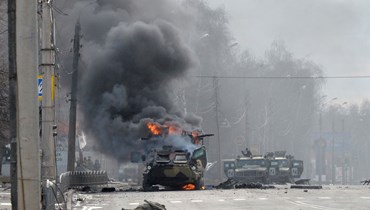 جثة جندي مجهول قرب ناقلة جند روسية تحترق خلال قتال مع القوات المسلحة الأوكرانية في خاركيف (27 شباط 2022، أ ف ب). 