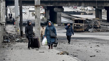 أشخاص حملوا أمتعتهم خلال سيرهم في احد الشوارع في كييف (4 آذار 2022، ا ف ب). 