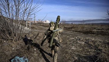 جندي أوكراني متوجها الى خط المواجهة في مدينة إربين شمال أوكرانيا (12 آذار 2022، ا ف ب). 