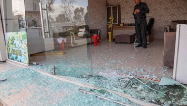 رجل يتفقد أضرارا لحقت بمتجر في أعقاب هجوم ليلي في أربيل (13 آذار 2022، ا ف ب). 