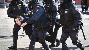 شرطيون يحتجزون رجلاً خلال تظاهرة في ميدان مانيجنايا بوسط موسكو احتجاجا على الغزو الروسي لأوكرانيا (13 آذار 2022، ا ف ب). 