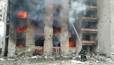 رجال إطفاء يطفئون حريقا اندلع في أحد المباني السكنية في تشيرنيهيف في أعقاب غارات جوية (13 آذار 2022، ا ف ب). 