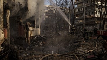 رجال إطفاء أوكرانيون يكافحون حريقا اندلع في مبنى سكني بعد قصف كييف (15 آذار 2022، ا ب). 