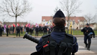 شرطيون يقفون أمام متظاهرين قبل اجتماع للمرشح للانتخابات الرئاسية إريك زمور في سان جان لو بلان بالقرب من أورليان وسط فرنسا (16 آذار 2022، أ ف ب). 