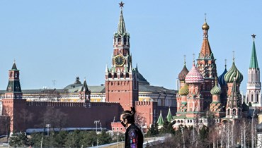 شخص يمشي على جسر بالقرب من الكرملين في وسط موسكو (22 آذار 2022، ا ف ب). 