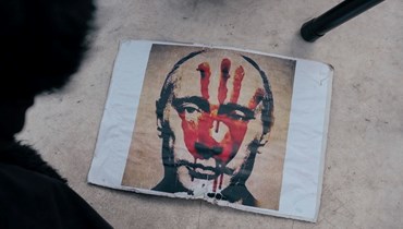لافتة تصور بوتين خلال مسيرة في بلغراد ضد الغزو العسكري الروسي لأوكرانيا (20 آذار 2022، ا ف ب). 