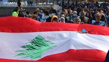 رفع العلم اللبناني في مسيرة احتجاجية (أرشيفية - حسن عسل).