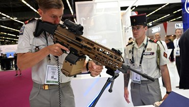 جندي فرنسي يحمل سلاحًا من صنع الشركة البلجيكية FN Herstal في معرض Eurosatory في فيلبينت، إحدى الضواحي الشمالية لباريس (13 حزيران 2022، أ ف ب). 