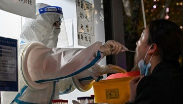 امرأة تجري اختبار كشف كورونا في منطقة جينغان بشنغهاي في الصين (28 ت2 2022، أ ف ب). 