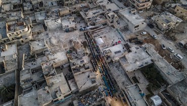 منظر الجوي للسكان المتضرّرين من زلزال 6 شباط وهم يحضرون عشاء إفطار في بلدة الأتارب في ريف حلب الغربي (أ ف ب). 