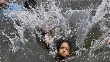 يسبح الأطفال في نهر في بنغلادش (أ ف ب). 