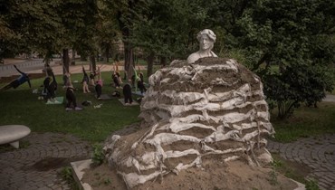   نصب تذكاري للشاعر الإيطالي دانتي أليغييري ، ملفوفاً بأكياس رمل لمنعه من التلف الناتج عن الهجمات الجوية الروسية، في كييف (أ ف ب). 