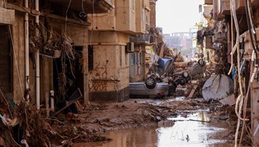 سيارات مقلوبة وسط ركام من جراء الفيضانات المفاجئة في درنة  شرق ليبيا (11 ايلول 2023، أ ف ب). 