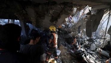 فلسطينيون يبحثون عن ناجين وضحايا في أعقاب غارة جوية إسرائيلية على مبنى في خان يونس بجنوب قطاع غزة (3 ت2 2023، أ ف ب).