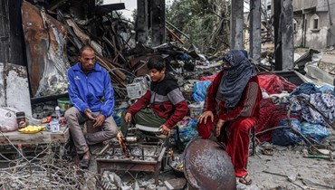 فلسطينيّون يعدّون الطعام وسط الدمار الذي خلّفته الغارات الإسرائيلية في قرية خزاعة شرق خان يونس (أ ف ب). 