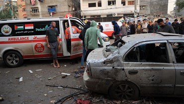 فلسطينيون تجمعوا بالقرب من سيارات إسعاف في أعقاب قصف إسرائيلي على رفح جنوب قطاع غزة (12 ك1 2023، أ ف ب). 