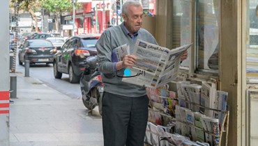 رجل يتصفّح جريدة "نداء الوطن" (نبيل إسماعيل). 