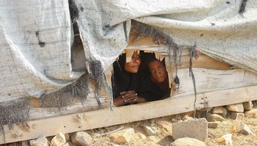 عائلة يمنيّة نازحة في مخيّم في مديرية عبس بمحافظة حجة (أ ف ب). 