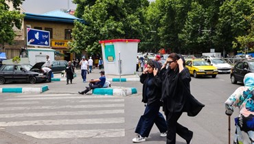 إيرانيتان تسيران في شوارع المدينة طهران (أ.ف.ب)