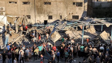 فلسطينيون يتجمعون للبحث في أنقاض مبنى منهار في أعقاب القصف الإسرائيلي على مدرسة الجاعوني التي تديرها وكالة الأمم المتحدة لإغاثة وتشغيل اللاجئين الفلسطينيين (الأونروا) في النصيرات بوسط قطاع غزة (6 تموز، 2024 - أ ف ب).