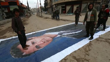 مقاتلون معارضون يدويون صورة الأسد.