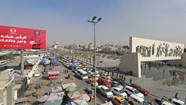 صورة ارشيفية- حركة المرور في ساحة التحرير ببغداد. وبدا نصب الحرية الشهير (7 ت2 2022، أ ف ب). 