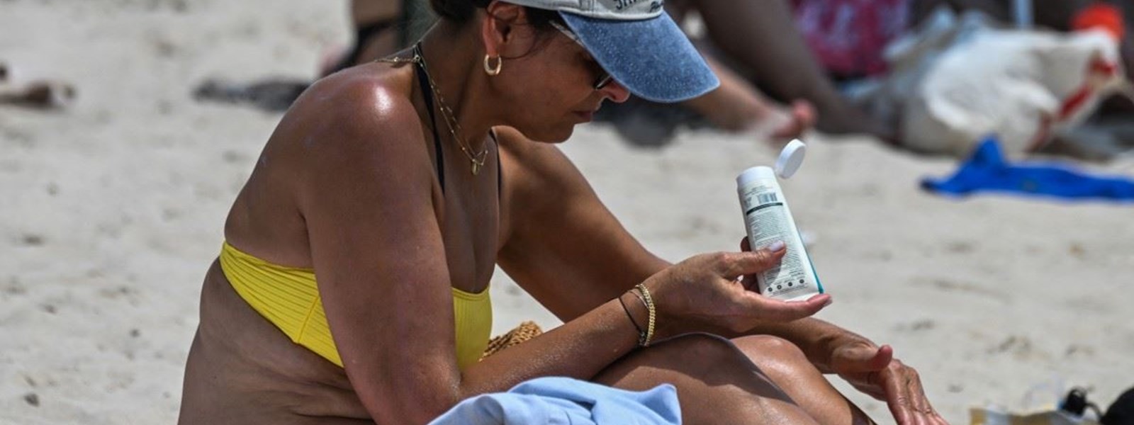 امرأة تتشمس على شاطئ خلال موجة حر شديدة في ميامي بيتش (16 تموز 2023، أ ف ب). 